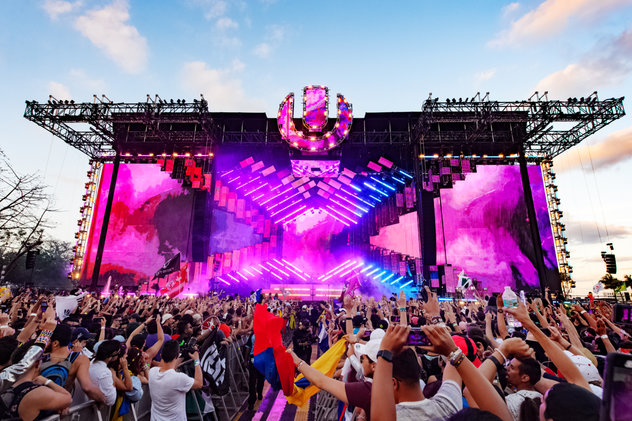 Image of audience with hands in the air in a musical festival