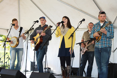 Woman singing while rest of the band playing instruments